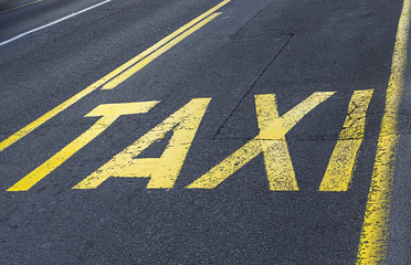 Yellow road sign on asphalt - taxi sign.