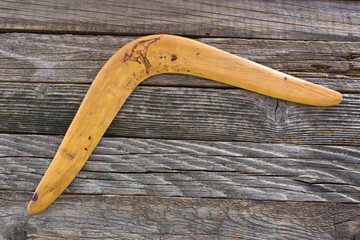 Boomerang on old wooden board - obrazy, fototapety, plakaty