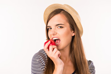 Girl with hat biting an apple