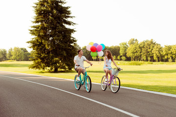 couple in love together to ride a bicycle with ballons