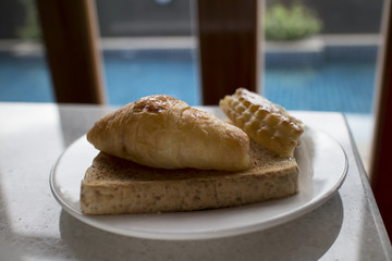 Bread, croissant and puff on the plate