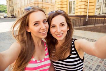 Friends making selfie. Two beautiful young women making selfie p