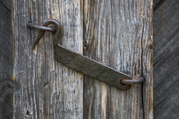 The door hook closes an old wooden door. 