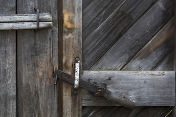 The door bolt closes an old wooden door. 