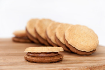 Fototapeta na wymiar Line chocolate sandwich cookies wooden board