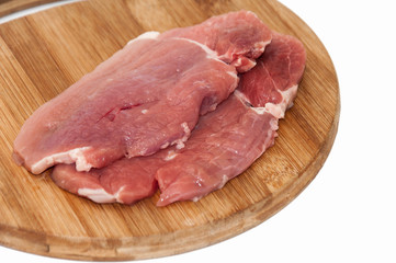 Raw steaks on wooden board