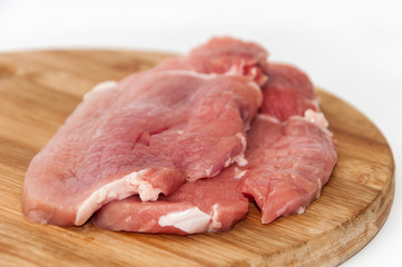 Raw steaks on wooden board