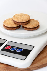 Chocolate sandwich biscuits on the digital scale