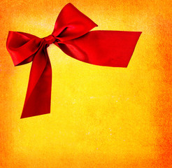 festive red bow on yellow textured background - copy space for t