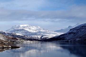 Naklejka na ściany i meble Spiegelbild schneebedeckter Berg im See