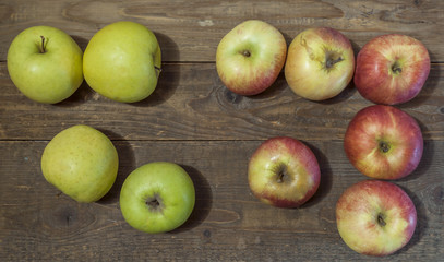 Green and red apples on a wooden background