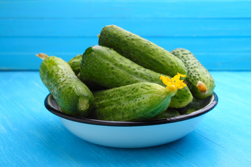 cucumbers in a white bowl on a blue background