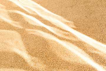 Light reflections create sand dunes effect on a road