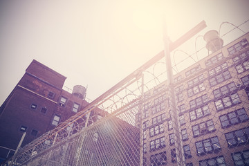 Retro toned building with barbed wire fence, New York, USA.