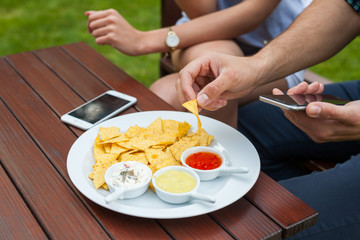 The close-up of eating tortilla-chips, there is telephone either.