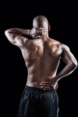 Fototapeta na wymiar Rear view of muscular athlete stretching