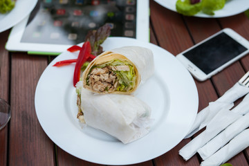 Close- up of tortilla with chicken in the accompaniment of table.