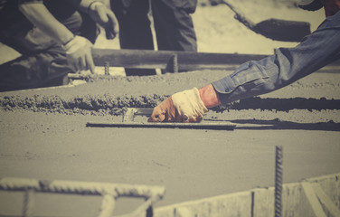 Construction worker leveling concrete pavement.