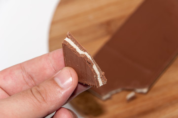 Hand holds piece of chocolate