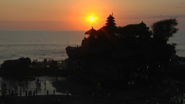 The sun silhouettes the Pura Tanah Lot temple in Bali, Indonesia.