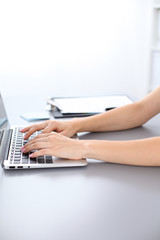 Close up of business woman hands typing on laptop computer