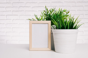Blank small wooden photo frame and house plant