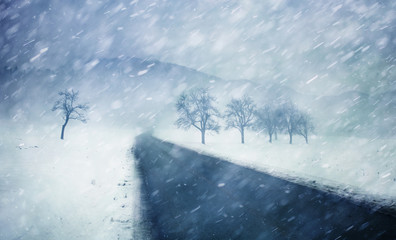 Heavy snowfall winter countryside road with trees. WInter snowy countryside landscape.