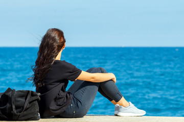  Young girl sitting on the beach.