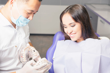Dentist doctor shows the patient's jaw with teeth