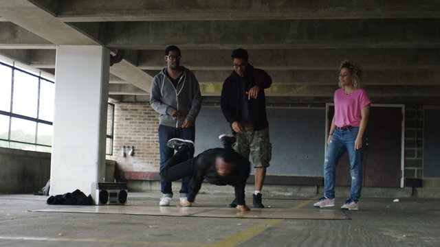 4K Male breakdancer performing as friends cheer him on,  shot on Red Epic Dragon