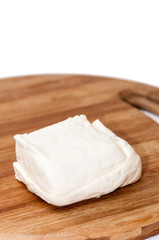Fototapeta na wymiar Homemade white cheese on the kitchen wooden board