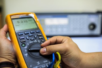 Technician turn switch of multimeter for calibration with precision multi calibrator
