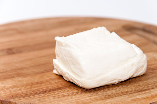 Homemade white cheese on the kitchen wooden board