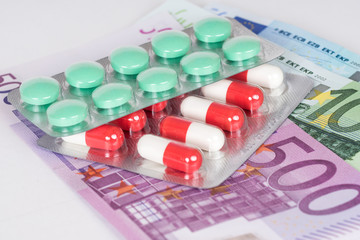 capsules and pills in blister with euro banknotes
