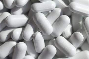 heap of white pills close up