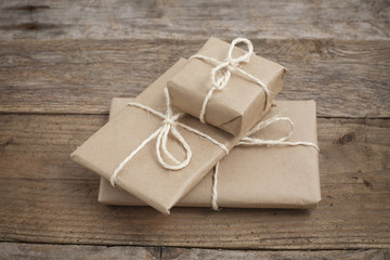Three gifts wrapped in brown paper