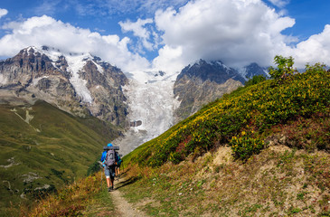 Naklejka na ściany i meble Group of tourists with large backpacks are on mountain
