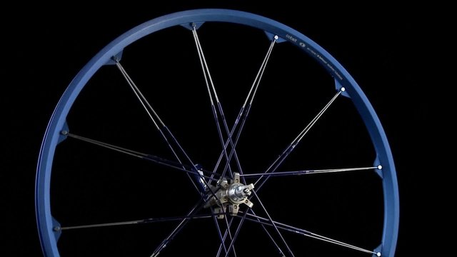 A Blue Wheel With Spokes Revolves.