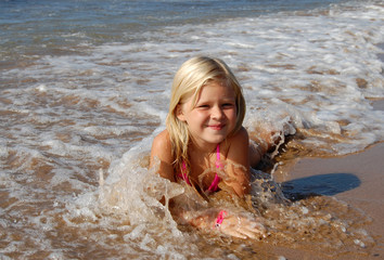 Little girl lying on the beach