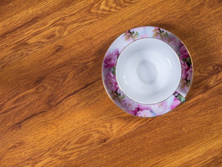 Top view on the cup with saucer, standing on the wooden table