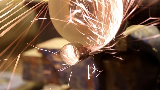 working with angle grinder, cutting pipe
