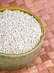 barley groats in a brown bowl 
