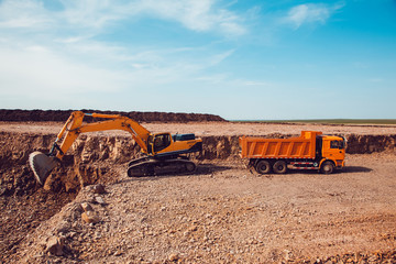 Excavator Loads Gravel into a Truck on a Crushed Stone Quarry