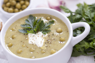 A delicious pea cream with aromatic spices on a wooden table.