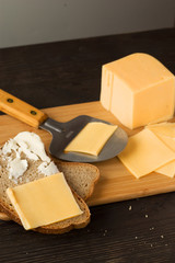 half a bun with cheese and blurry bread rolls in the background