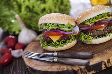 Beef burgers on a wooden board with aromatic spices