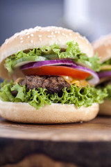 Beef burgers on a wooden board with aromatic spices