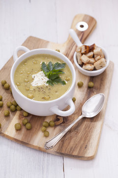 A delicious pea cream with aromatic spices on a wooden table.