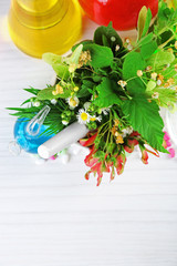 Herbs in mortar, test tubes and pills,  on table background