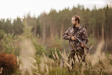 Papier Peint photo Chasser Young male hunter in camouflage clothes ready to hunt  with hunt